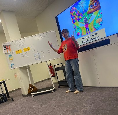 Workshop für Eltern und Pädagogen: Nathalie Barth erklärt vor einem Whiteboard und einer Präsentation